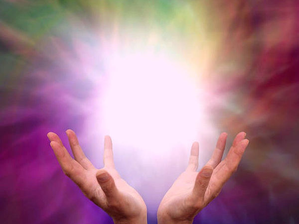Mains ouvertes entourées d'un halo de lumière mauve